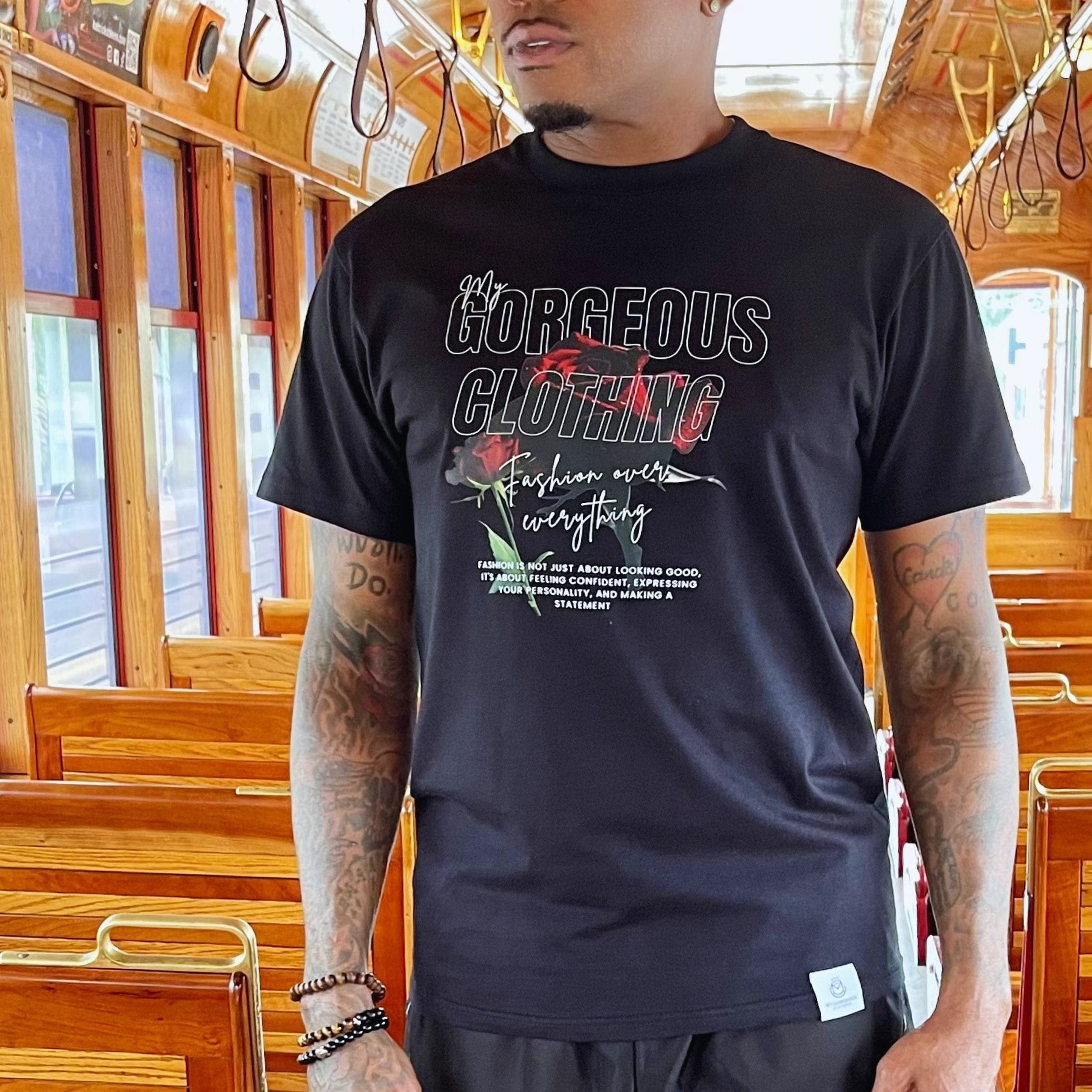 Person wearing a black t-shirt with text and graphics inside a vehicle.